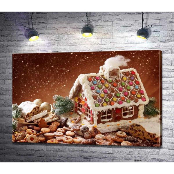 Пряничный домик с глазурью в окружении праздничного печенья