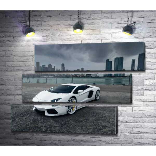 Білосніжний автомобіль Ламборгіні (Lamborghini) на фоні передгрозового мегаполісу