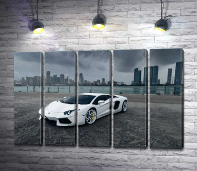 Білосніжний автомобіль Ламборгіні (Lamborghini) на фоні передгрозового мегаполісу