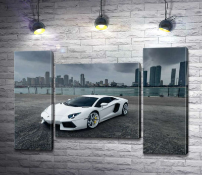 Білосніжний автомобіль Ламборгіні (Lamborghini) на фоні передгрозового мегаполісу