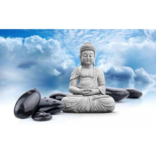 Будда в позі лотоса серед чорного каміння на фоні лазурового неба