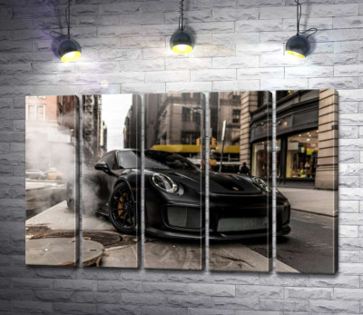 Вугільно-чорний автомобіль  Порше (Porsche) 911 серед вулиці старого міста