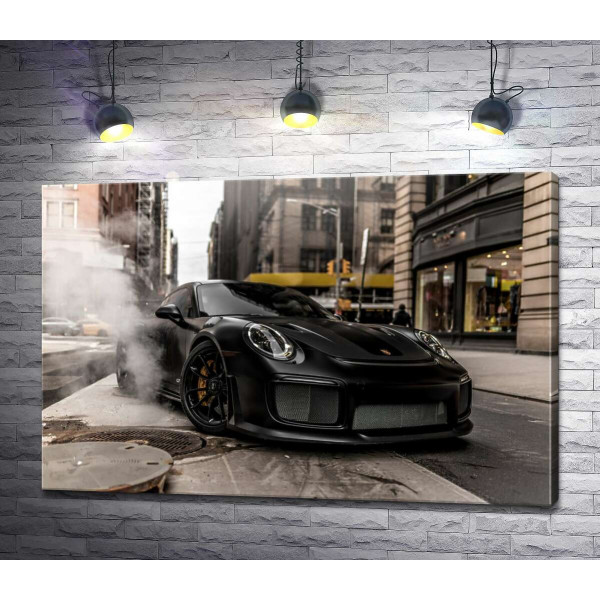 Вугільно-чорний автомобіль  Порше (Porsche) 911 серед вулиці старого міста