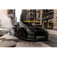 Угольно-черный автомобиль Порше (Porsche) 911 среди улицы старого города