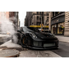 Вугільно-чорний автомобіль  Порше (Porsche) 911 серед вулиці старого міста
