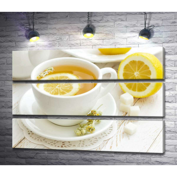 Контраст желтого и белого в чашке лимонного чая с засушенными цветами полыни