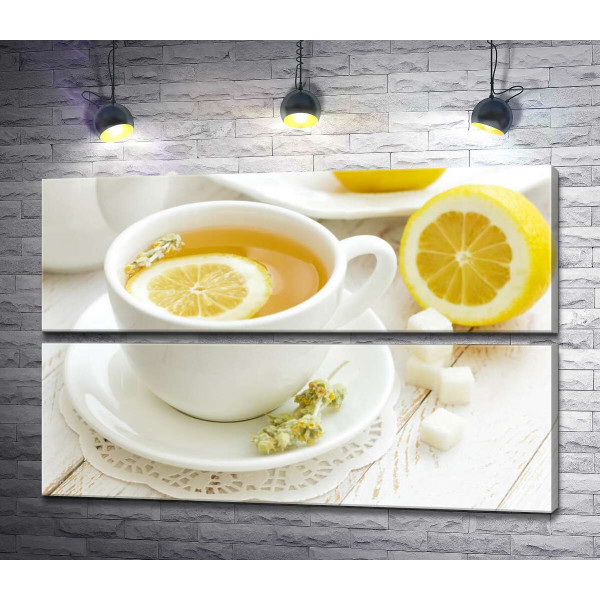 Контраст желтого и белого в чашке лимонного чая с засушенными цветами полыни