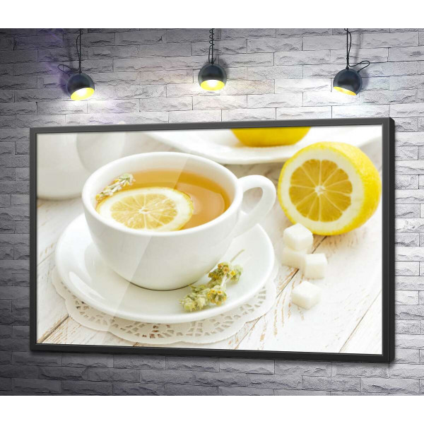 Контраст жовтого та білого у чашці лимонного чаю із засушеними квітами полину