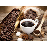 Чашка с ароматным кофе среди зерен и пряностей