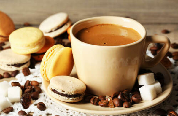 Кремовые оттенки в чашке с кофе и пирожными макаронов