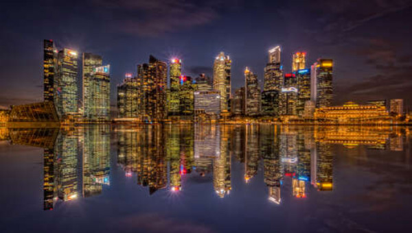 Зеркальные отражения ночных домов у набережной Сингапура