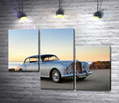 Серый автомобиль Bentley S2 на фоне морского берега