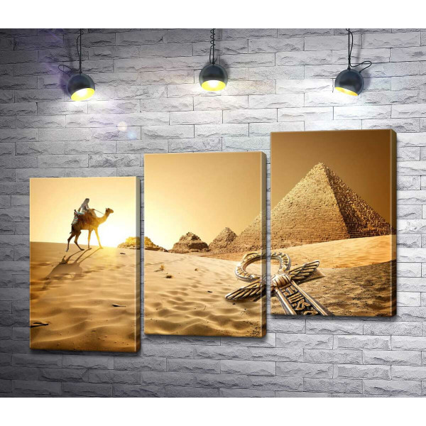 Символ життя - анх в пісках пустелі на фоні єгипетських пірамід 