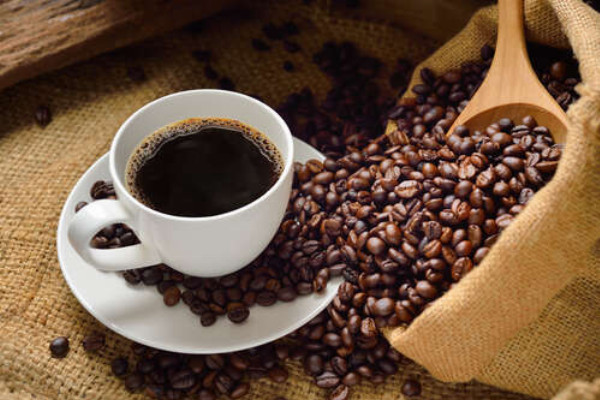 Терпке американо в оточенні блискучих кавових зерен