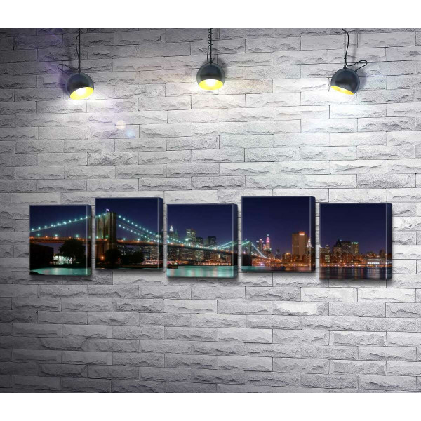 Гирлянды фонарей Бруклинского моста (Brooklyn Bridge) отражаются в водах пролива Ист-ривер (East River)