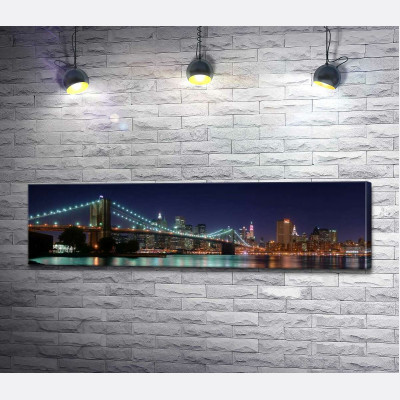 Гірлянди ліхтарів Бруклінського мосту (Brooklyn Bridge) відбиваються у водах протоки Іст-рівер (East River)