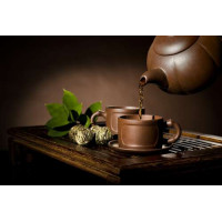 Горячий травяной чай наполняет стилизованные чашки