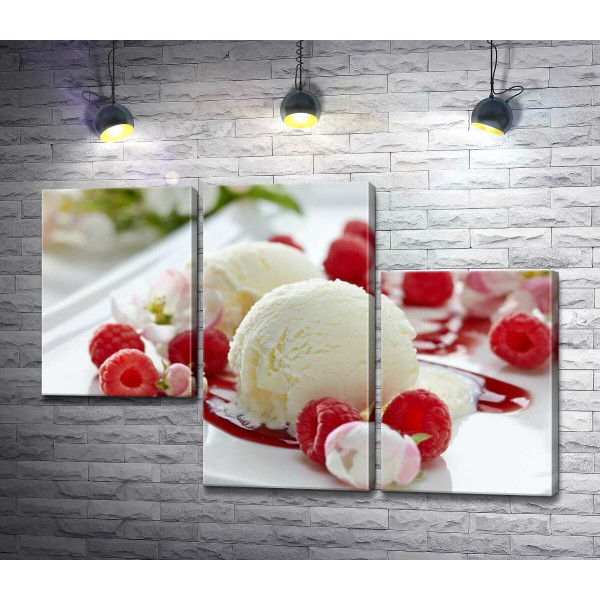 Шарики ванильного мороженого на тарелке с ягодами малины и нежными цветами
