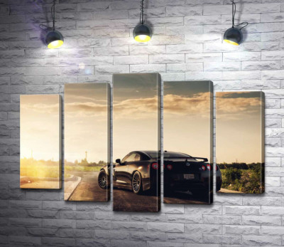 Лучи сверкают золотом на черной поверхности автомобиля Opel