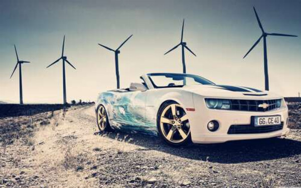 Белый автомобиль кабриолет Chevrolet Camaro на фоне ветряных электростанций