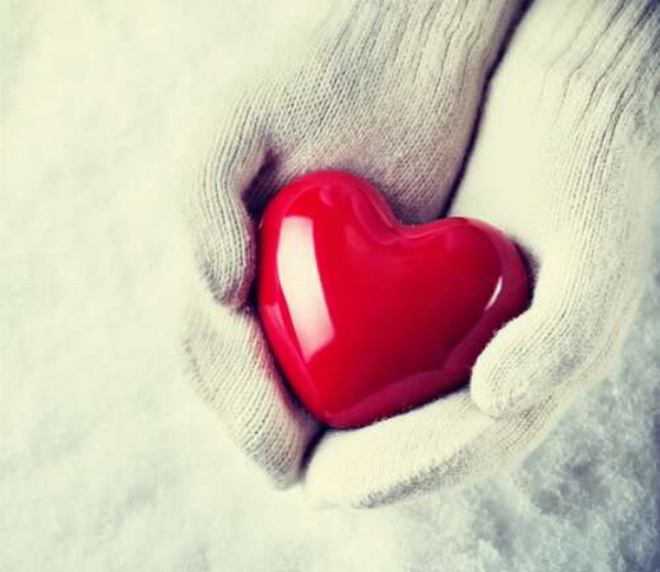 Теплий колір серця на холодному фоні білих рукавичок