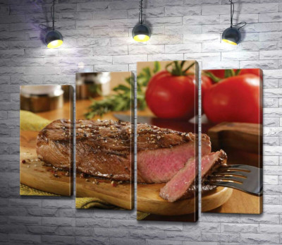 Розовое мясо сочного стейка на фоне красных помидоров