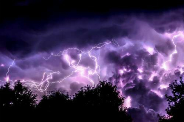 Грозовое небо, подсвеченное молниями, горит фиолетовыми оттенками