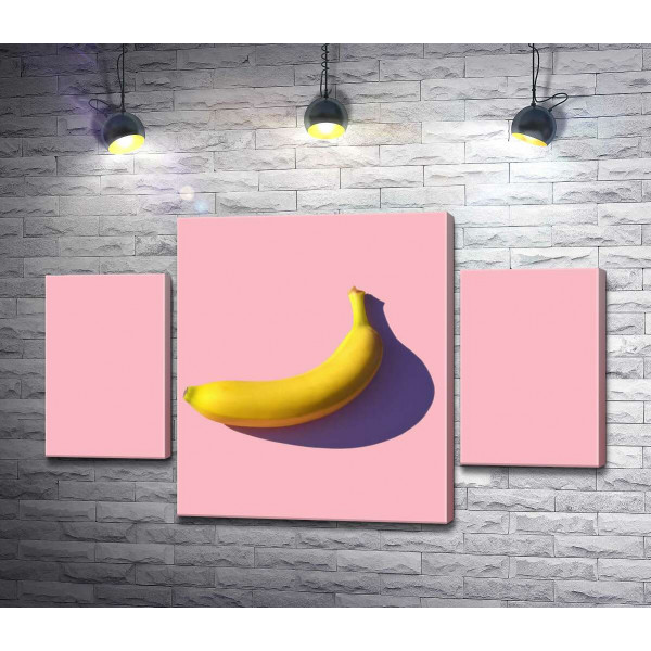 Сонячного кольору банан кидає фіолетову тінь на рожевий фон