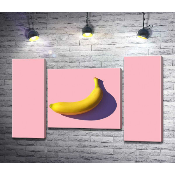 Сонячного кольору банан кидає фіолетову тінь на рожевий фон