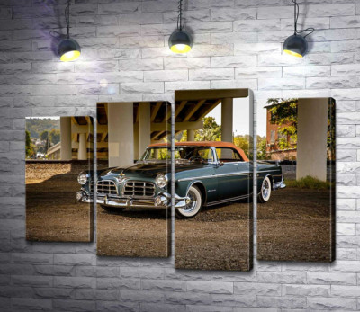 Темный автомобиль кабриолет Chrysler 1955 стоит в тени моста