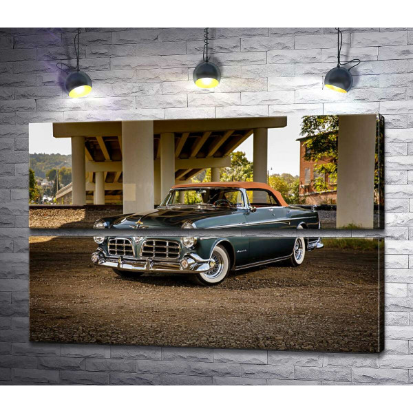 Темний автомобіль кабріолет Chrysler 1955 стоїть в тіні мосту