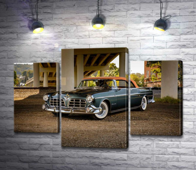 Темний автомобіль кабріолет Chrysler 1955 стоїть в тіні мосту