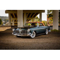 Темный автомобиль кабриолет Chrysler 1955 стоит в тени моста