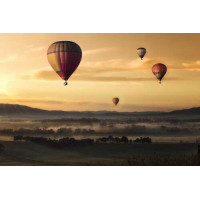 Воздушные шары встречают утро над туманной равниной