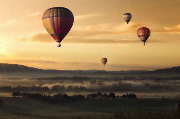 Воздушные шары встречают утро над туманной равниной