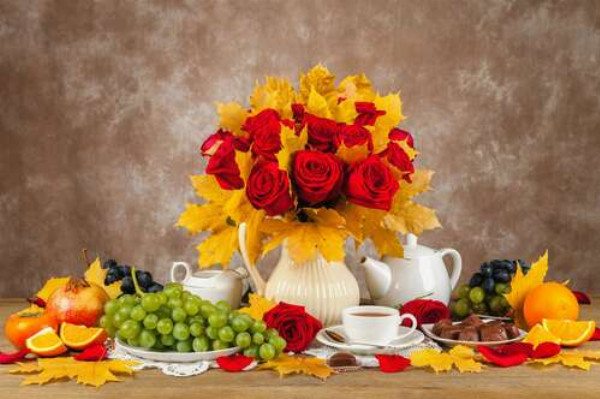Осінній натюрморт з кленовим листям, букетом троянд, виноградом та чаєм