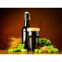 Бутылка рядом с бокалом черного пива в окружении хмеля и пшеницы