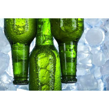 Прозрачные капли воды стекают по зеленому стеклу бутылок с пивом