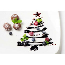 Шоколадная глазурь в форме елки рядом со свежими кексами