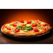 Пышный слой теста в пицце, украшенной слайсами помидоров и базиликом