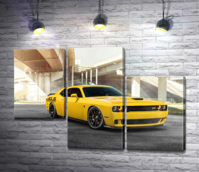 Желтый автомобиль Dodge Challenger Hellcat остановился под мостом