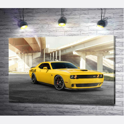 Желтый автомобиль Dodge Challenger Hellcat остановился под мостом