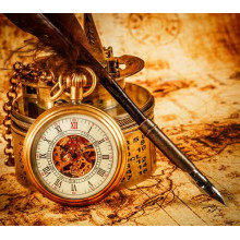 Вінтажний кишеньковий годинник обперся на компас поряд з пір'яною ручкою