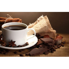 Чашка кофе в окружении пряностей, шоколада и орехов