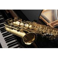 Золотой силуэт саксофона контрастирует с черной поверхностью рояля