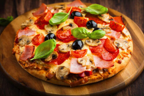 Ровные края круглой пиццы с мясом, грибами, помидорами, базиликом и маслинами