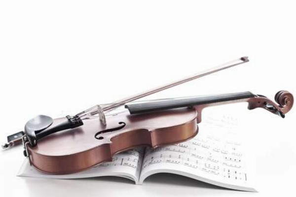 Смичок та скрипка лежать на книжці з нотами