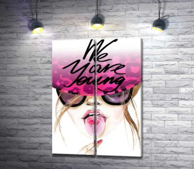 Дівчина з льодяником в рожевій шляпі з написом "we are young"