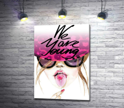 Девушка с леденцом в розовой шляпе с надписью "we are young"