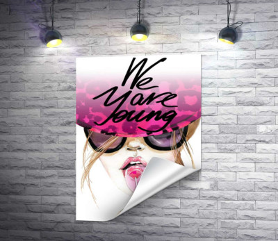 Девушка с леденцом в розовой шляпе с надписью "we are young"